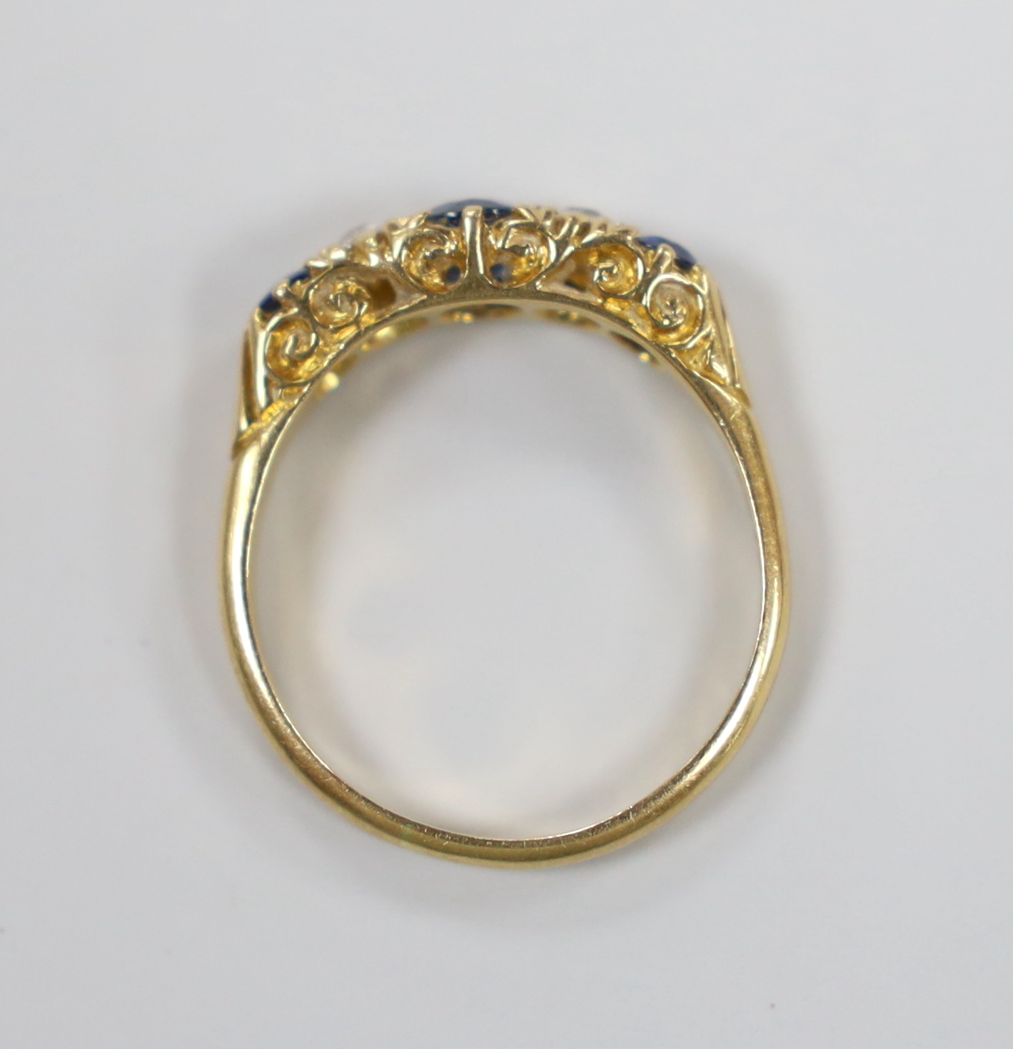 A late Victorian 18ct gold, three stone sapphire and two stone diamond set half hoop ring, size P, gross weight 3.8 grams.